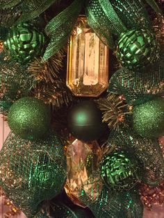 a green christmas wreath with ornaments on it