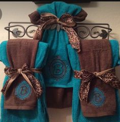 the towels are hanging up on the towel rack in the bathroom, and one is blue with brown leopard print