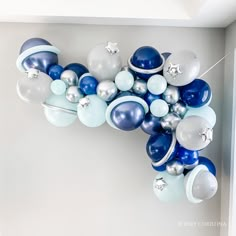 blue and white balloons are hanging from the ceiling