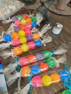 plastic easter eggs wrapped in cellophane and sitting on a table next to cans of paint