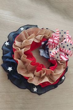 a patriotic wreath with red, white and blue bows on it sitting on a table