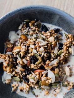 a bowl filled with granola and nuts on top of a table