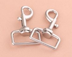 two metal clips on a pink background