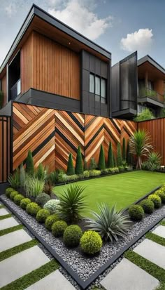 an outdoor garden with grass and plants in front of a wooden fence on the side of a building