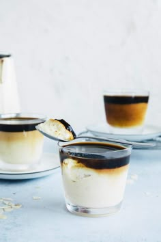 two glasses filled with coffee sitting on top of a table