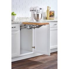 a kitchen with white cabinets and an open cabinet in the middle that has a mixer on it