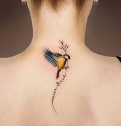 the back of a woman's neck with a small bird tattoo on her left side