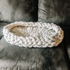 a white crocheted blanket sitting on top of a couch