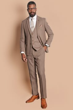 With its neutral colour and slim fit, this tailored suit is a three-piece you'll look forward to showing off. The style boasts the bespoke MD circle print lining, notch lapels with MD badge and is trimmed with marbled buttons. Features Slim fit Single-breasted waistcoat Notch lapel Double back vent Four button cuff Double button blazer fastening Complimentary pocket square Waistcoat adjuster straps Functional inside and outside pockets to the blazer Style Tip | Accessorise with tan to match the Linen Suit Brown Shoes, Taupe Suit Wedding, Taupe Tuxedo Wedding, Neutral Wedding Guest Outfit Men, Taupe Suits Wedding Men, Light Brown Groomsmen Suits, Dark Tan Suit, Tan Suits For Wedding, Tan Suit Men