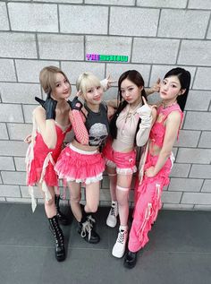 four young women dressed in pink posing for the camera