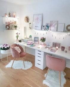 a white desk with pink chairs and pictures on the wall above it in a bedroom