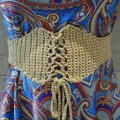 a close up of a woman's belt on a mannequin torso, with an intricate crochet design