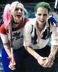 two people dressed up as the joker and harley in front of a car with graffiti on their face