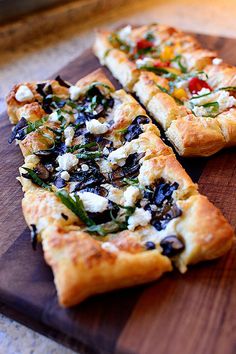 three slices of pizza sitting on top of a wooden cutting board