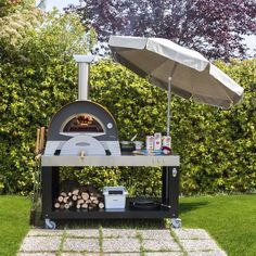 an outdoor pizza oven with umbrella over it