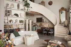 a living room filled with furniture and lots of shelves full of books on top of them