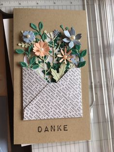 there is a card with flowers in an envelope that says danke on the front