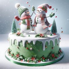 two snowmen standing on top of a green cake covered in frosting and decorations