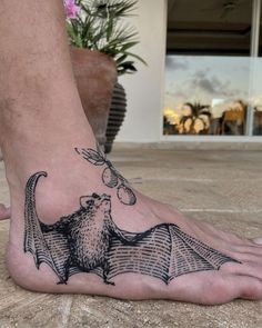 a person with a bat tattoo on their foot