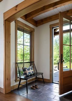 a wooden bench sitting in front of two windows