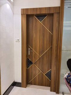 a wooden door in the middle of a room with white walls and black flooring