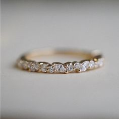 a gold wedding band with five pear shaped diamonds