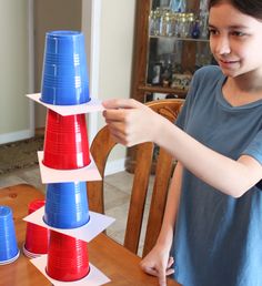 a young boy is playing with plastic cups