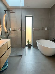 a bathroom with a large white bath tub sitting next to a walk in shower