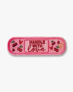 a pink patch that says handle with care on the front and back of it,