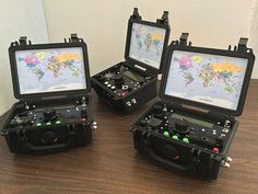 four electronic devices sitting on top of a wooden table next to each other with maps in them