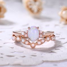 an opal and diamond ring set on top of a doily