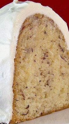 a piece of cake with white frosting on top sitting on a red tablecloth