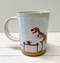 a coffee mug with a dinosaur on it