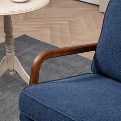 a blue chair sitting on top of a rug next to a table