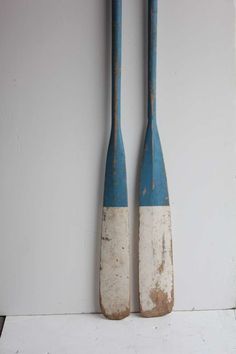 two blue and white wooden paddles hanging on the wall