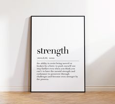 a black and white poster with the words strength on it next to a wooden floor