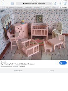 there is a doll house with furniture and decor on the wooden floor in front of it