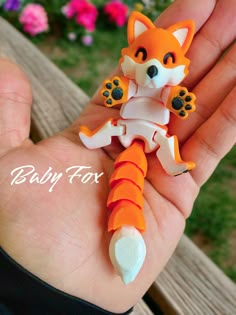 a small orange and white toy in someone's hand