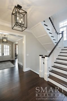 a staircase leading up to the second floor in a house with white walls and wood floors