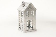 a small metal house on a white surface