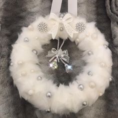 a white christmas wreath with bows and pearls