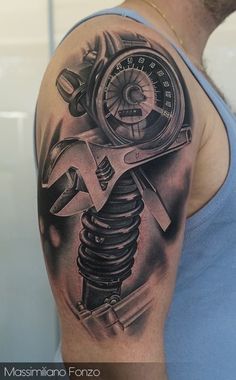 a man with a tattoo on his arm holding a wrench