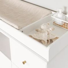 an open drawer in a white dresser with soaps and other items on it,