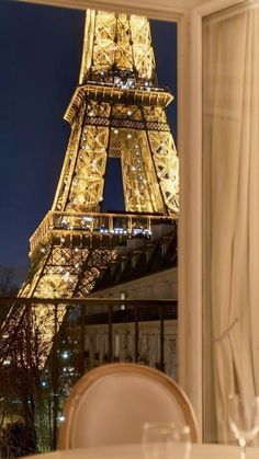 the eiffel tower lit up at night seen from inside a restaurant in paris, france