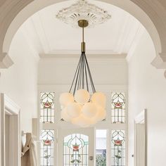 an entryway with stained glass windows and a chandelier hanging from the ceiling