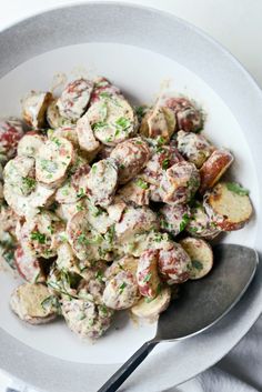 a white bowl filled with potato salad on top of a table