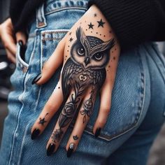 an owl with stars on it's hand and some tattoos on the other hand