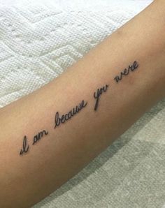 a person with a tattoo on their arm that says i am because you are