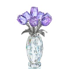 a crystal vase with purple flowers in it