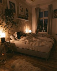 a bed in a room with lights on the floor and pictures hanging above it,